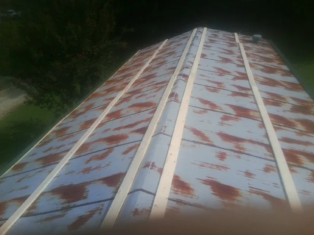 Rusted metal roof panels with new wood purlins before replacement — Storm Damage Roof Repair in Nova by Roofing Brothers