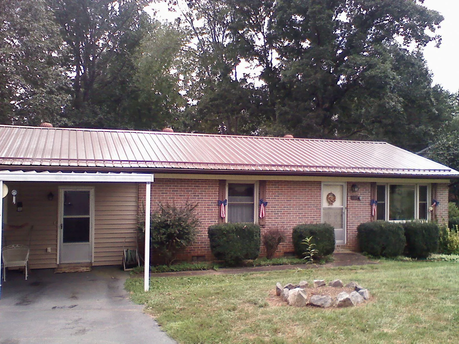 Bronze metal roof and carport on a brick ranch home — Roof Repair work by our crew in Nova